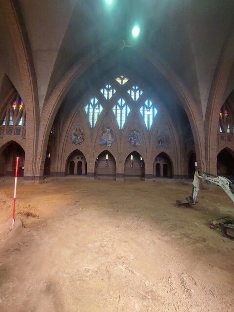 Binnenkant van de kerk genomen vanuit het altaar. De vloer is uitgebroken en alleen zand