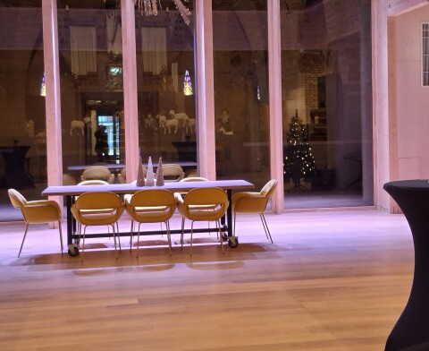 Grote zaal met een tafel en sfeerverlichting