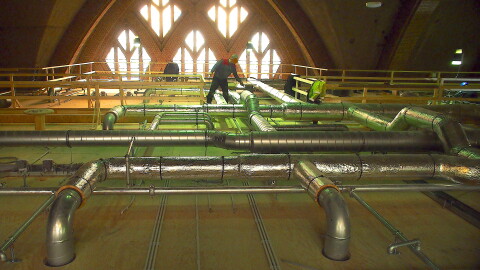 Bovenop het dak lopen buizen voor de airco